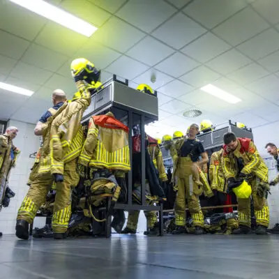 Ploeg van Brandweer Venlo trekken de uitrukkleding in de kleedruimte van Brandweer Venlo
