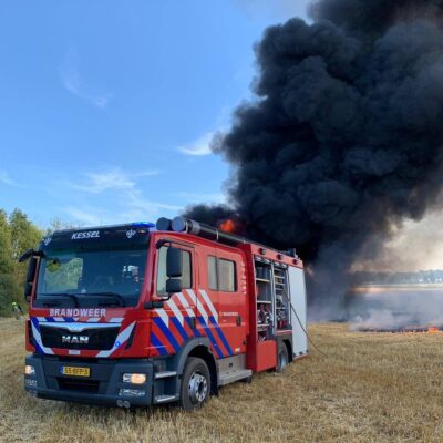 Tankautospuit Brandweer Kessel in de natuur, met een brand op de achtergrond