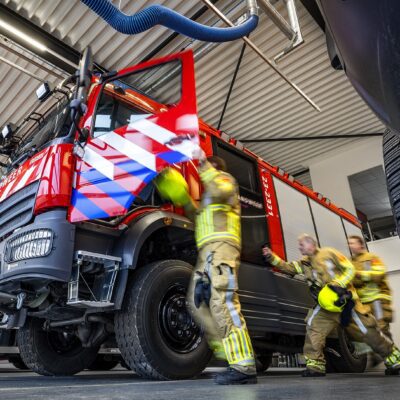 brandweermensen rukken uit en rennen richting de tankautospuit