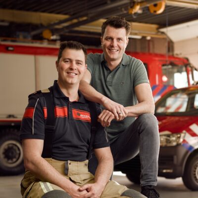 Brandweervrijwilliger Mark en zijn broer Tom poseren in een kazerne