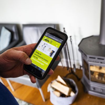 Mobiele telefoon met de website van schoorsteenveger.nl om een erkende schoorsteenveger te vinden