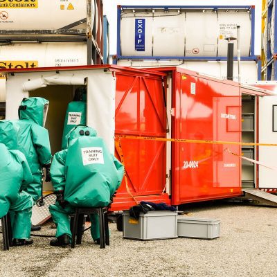 Mensen in pak tijden een oefening met gevaarlijke stoffen