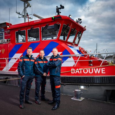 Drie collega's van brandweer Gelderland-Zuid voor de blusboot die in de haven ligt