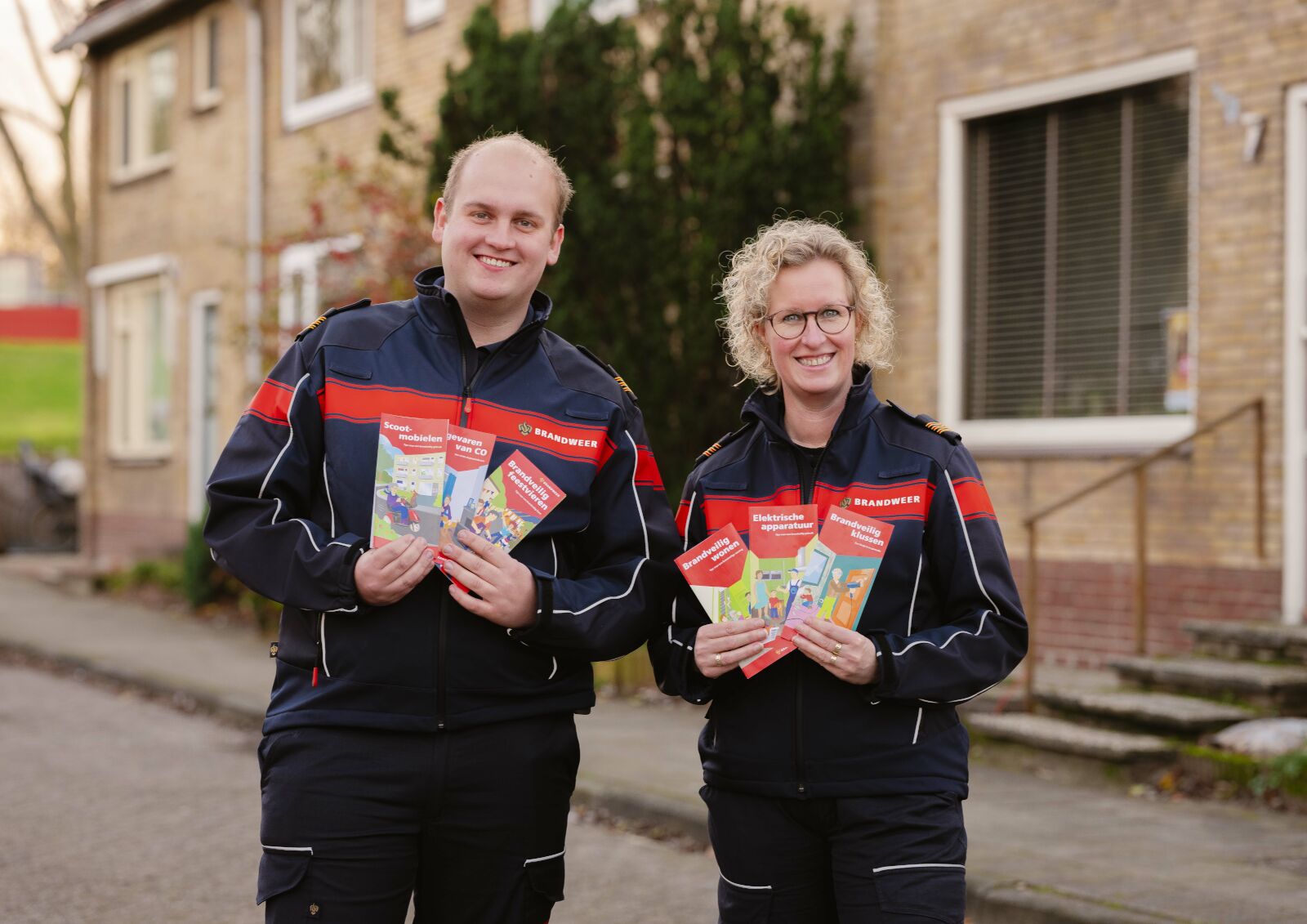 twee brandweermensen met flyers