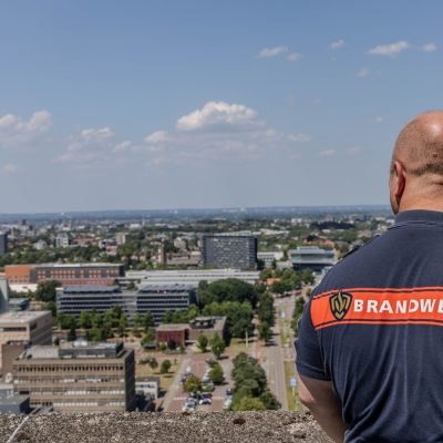 Rug van brandweercollega op een gebouw met uitzicht over Nijmegen