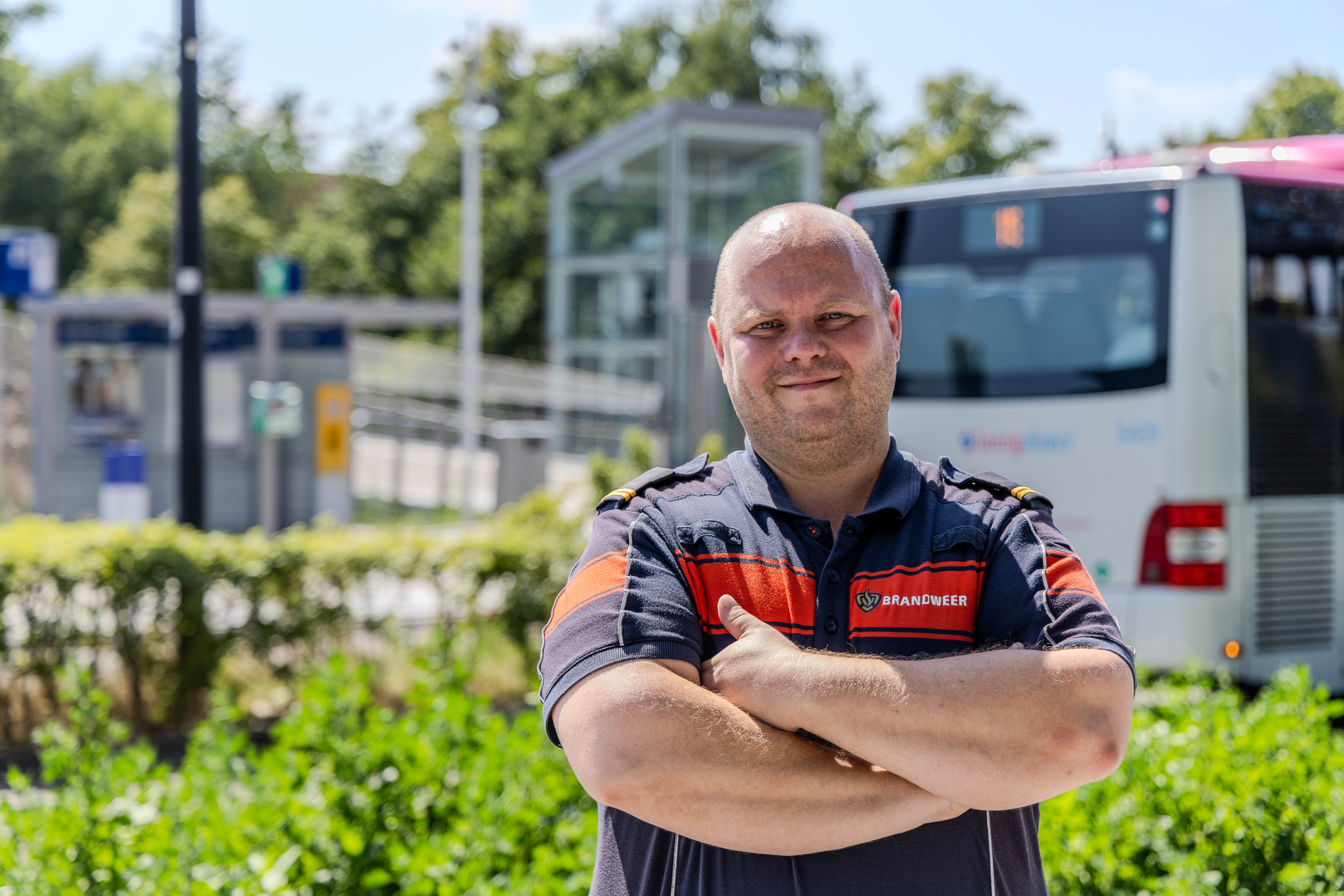 Brandweercollega met handen over elkaar voor een busstation in Nijmegen