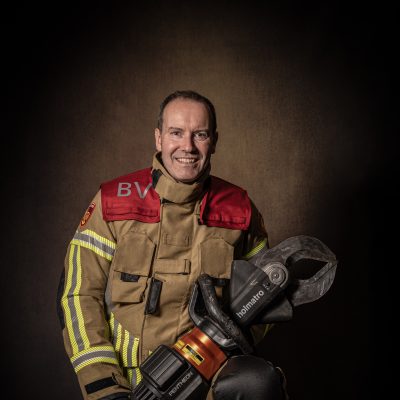 Man in brandweeruniform met hydraulisch gereedschap in zijn hand