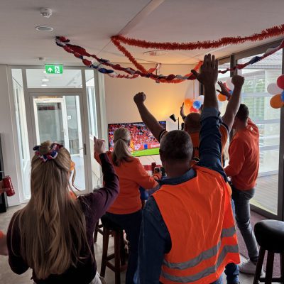 Juichende mensen in oranje kleding die naar wedstrijd van oranje aan het kijken zijn