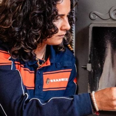 Veilig stoken: brandweermedewerker steekt een houtkachel aan tijdens de campagne Veilige warme winter.
